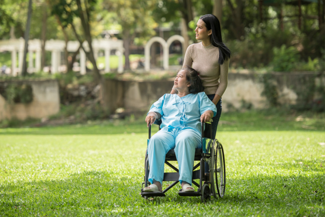 Beautiful girl visiting garden with old patient